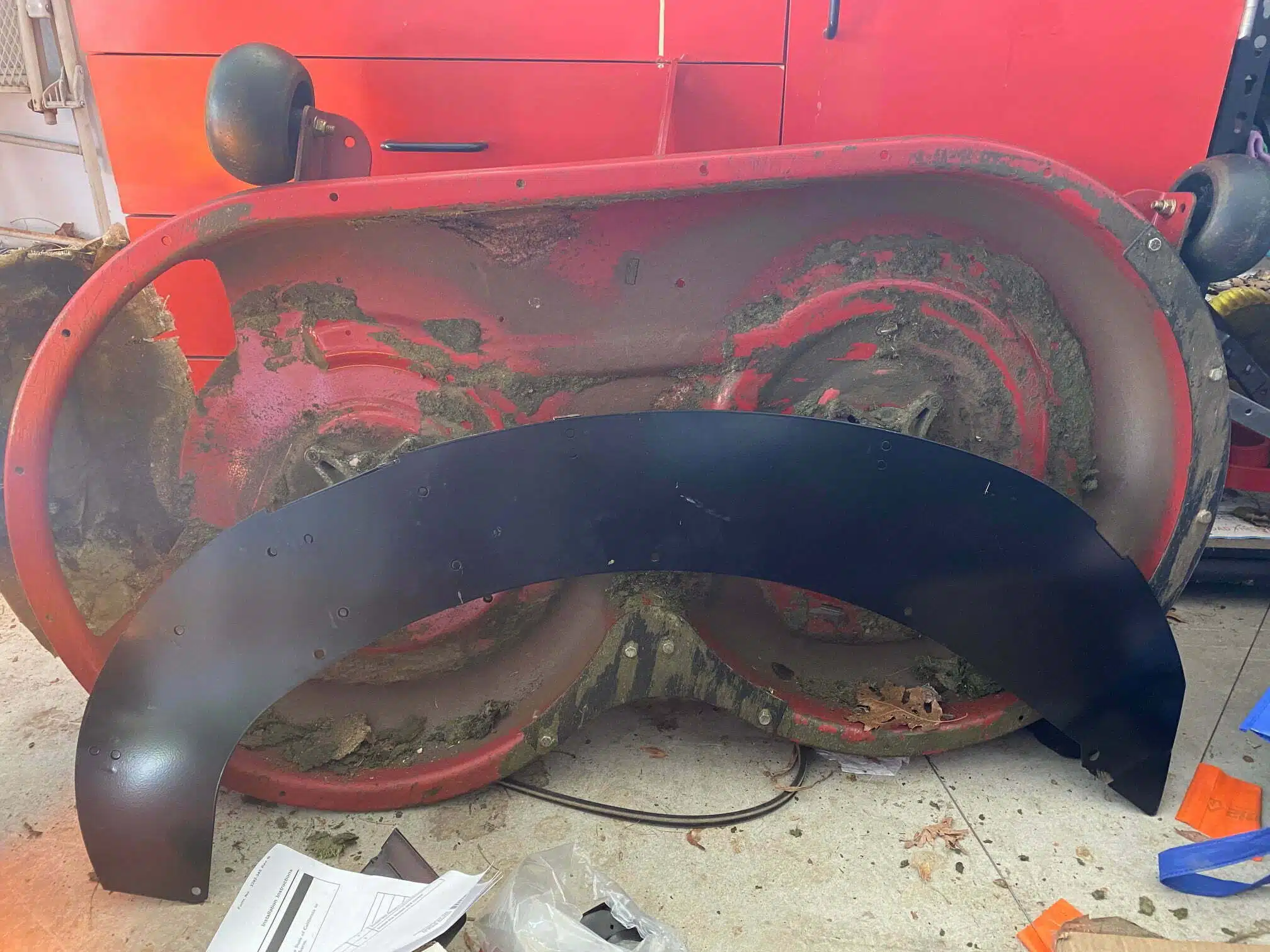 Cleaning packed grass clippings from under a riding lawn mower deck