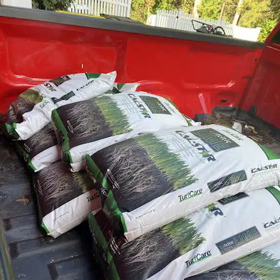 Bags of lime loaded in the bed of the Lawn Phix truck