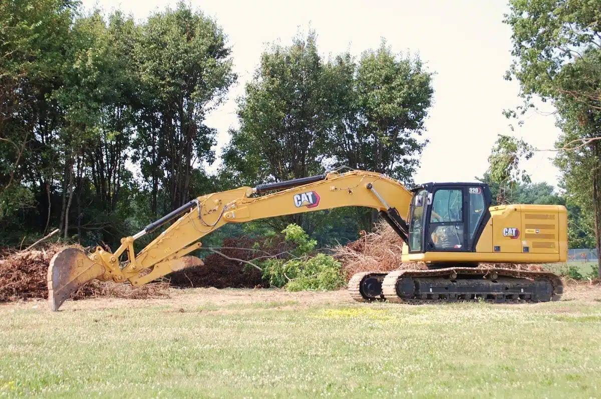 Excavator clearing land